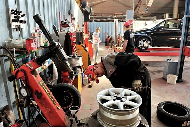 Monteur werkt aan een velg tijdens de bandenservice in de werkplaats