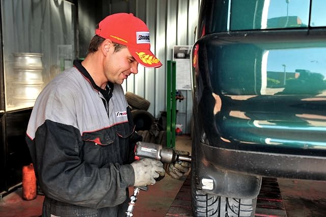 Monteur met slagmoersleutel aan het werk bij een wagen in de werkplaats in Eeklo
